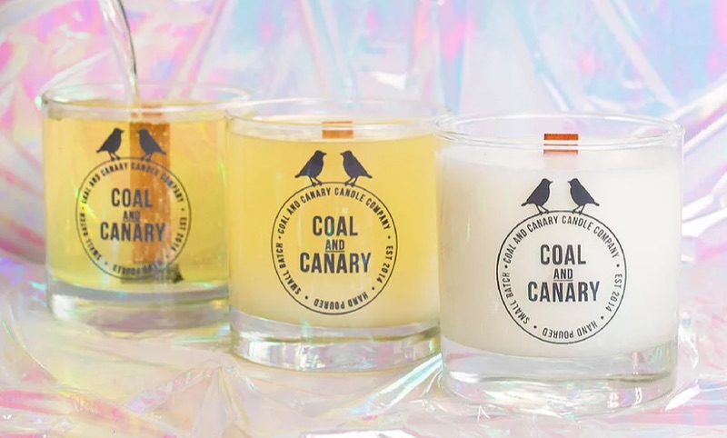 Three Coal and Canary brand candles on top of cellophane.