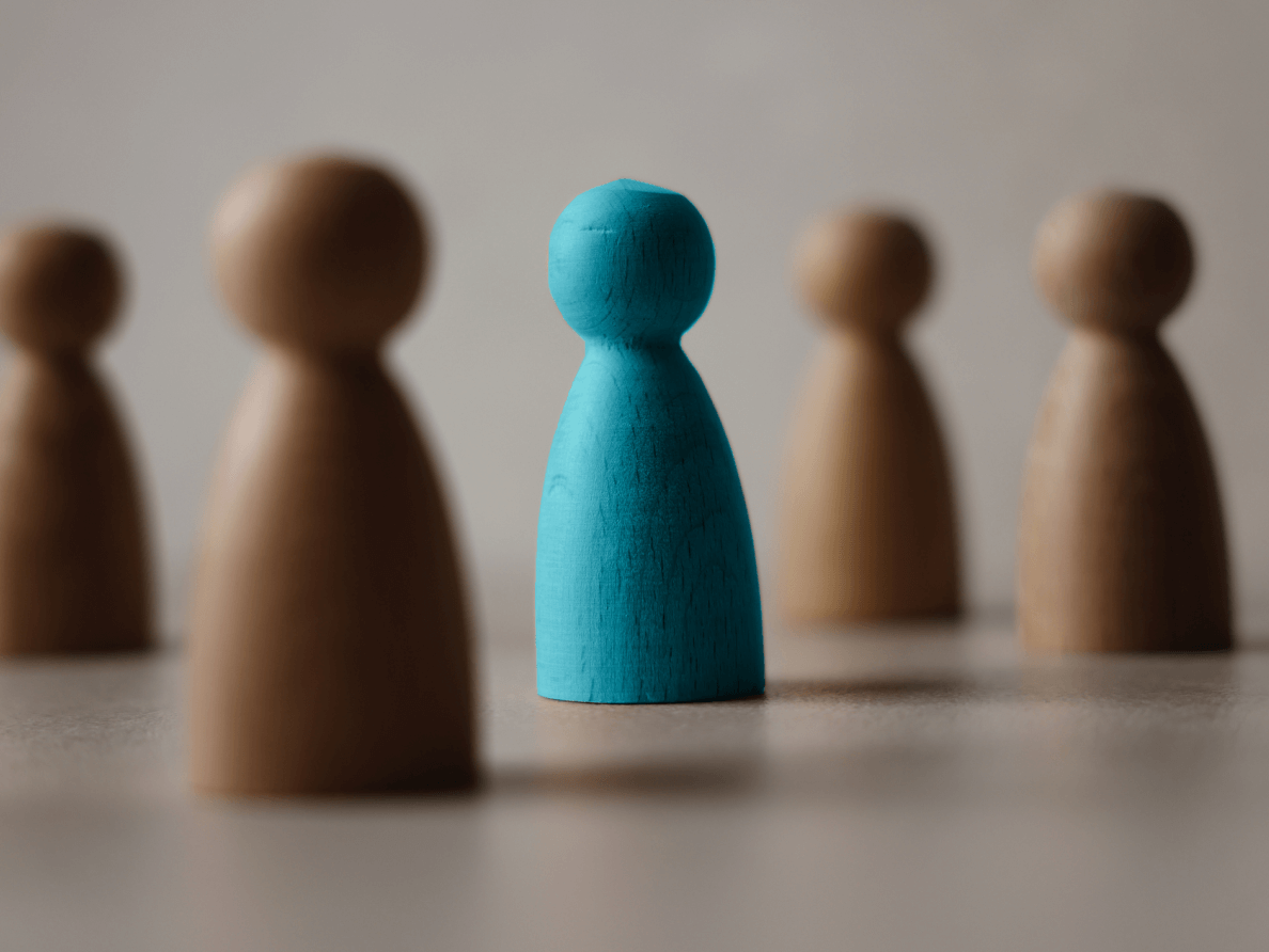 A blue game piece stands out among several other beige game pieces. 