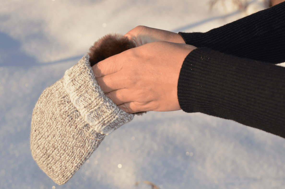 A person wears Aurora Heat handwarmers. 