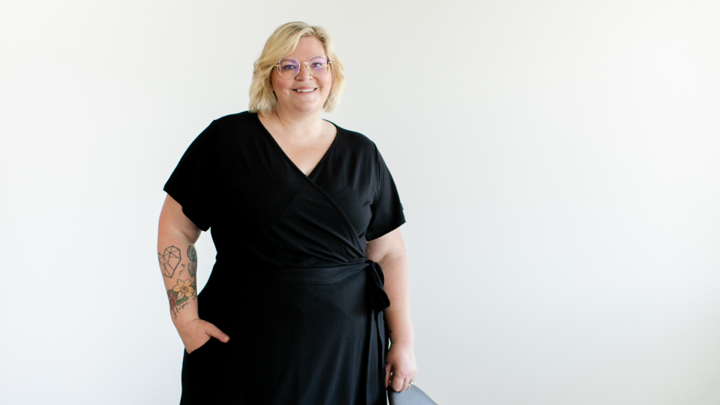 A plus size woman wears a black outfit from Buttercream Clothing.