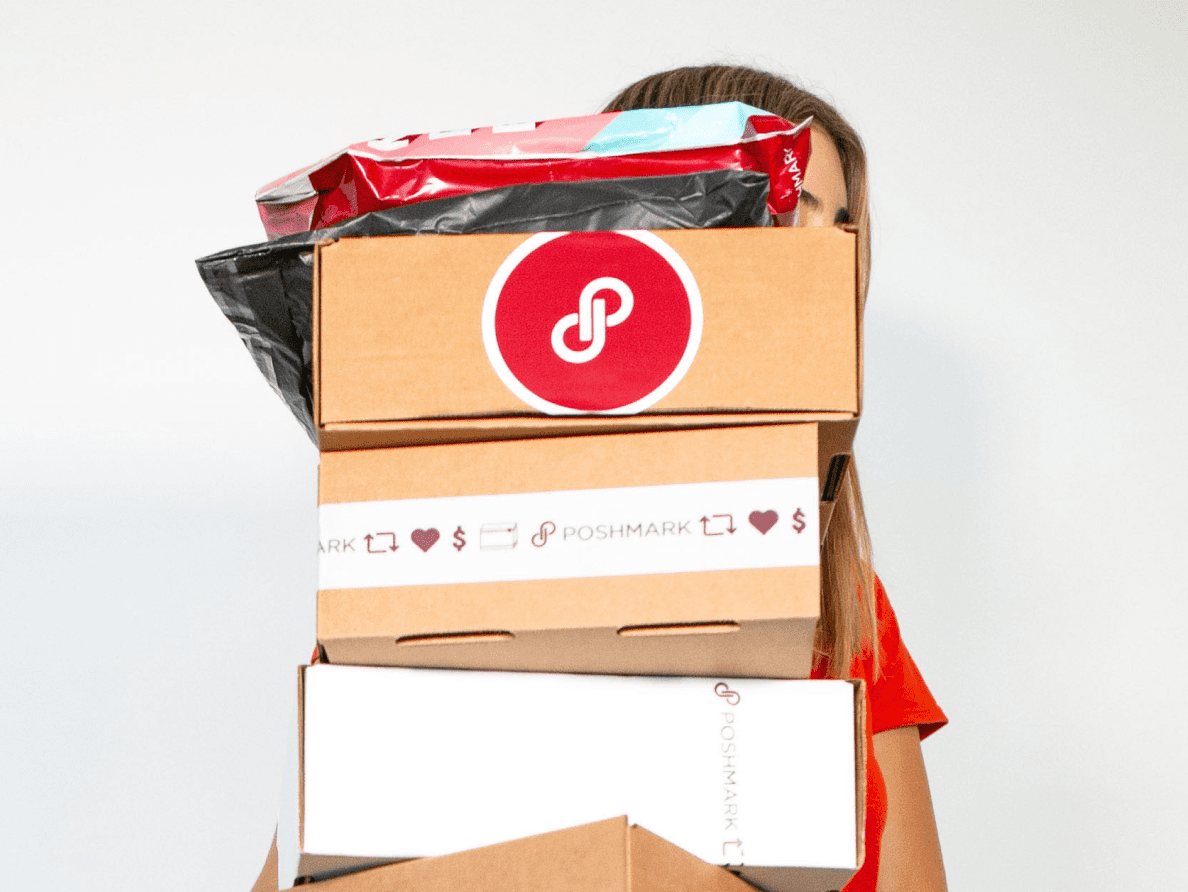 A woman holds several packages from Poshmark.