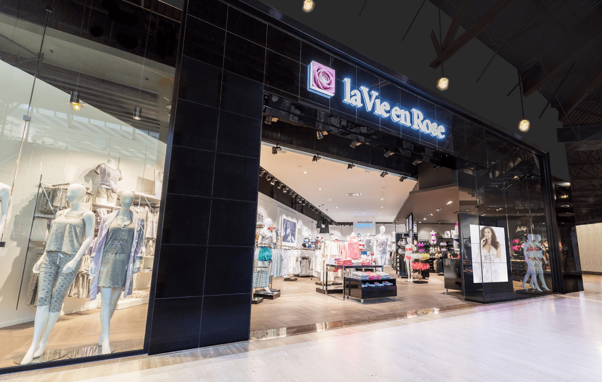 Vue sur la devanture d'une boutique la Vie en Rose dans un centre commercial. Dans la vitrine, des mannequins sont vêtus de vêtements de nuit.