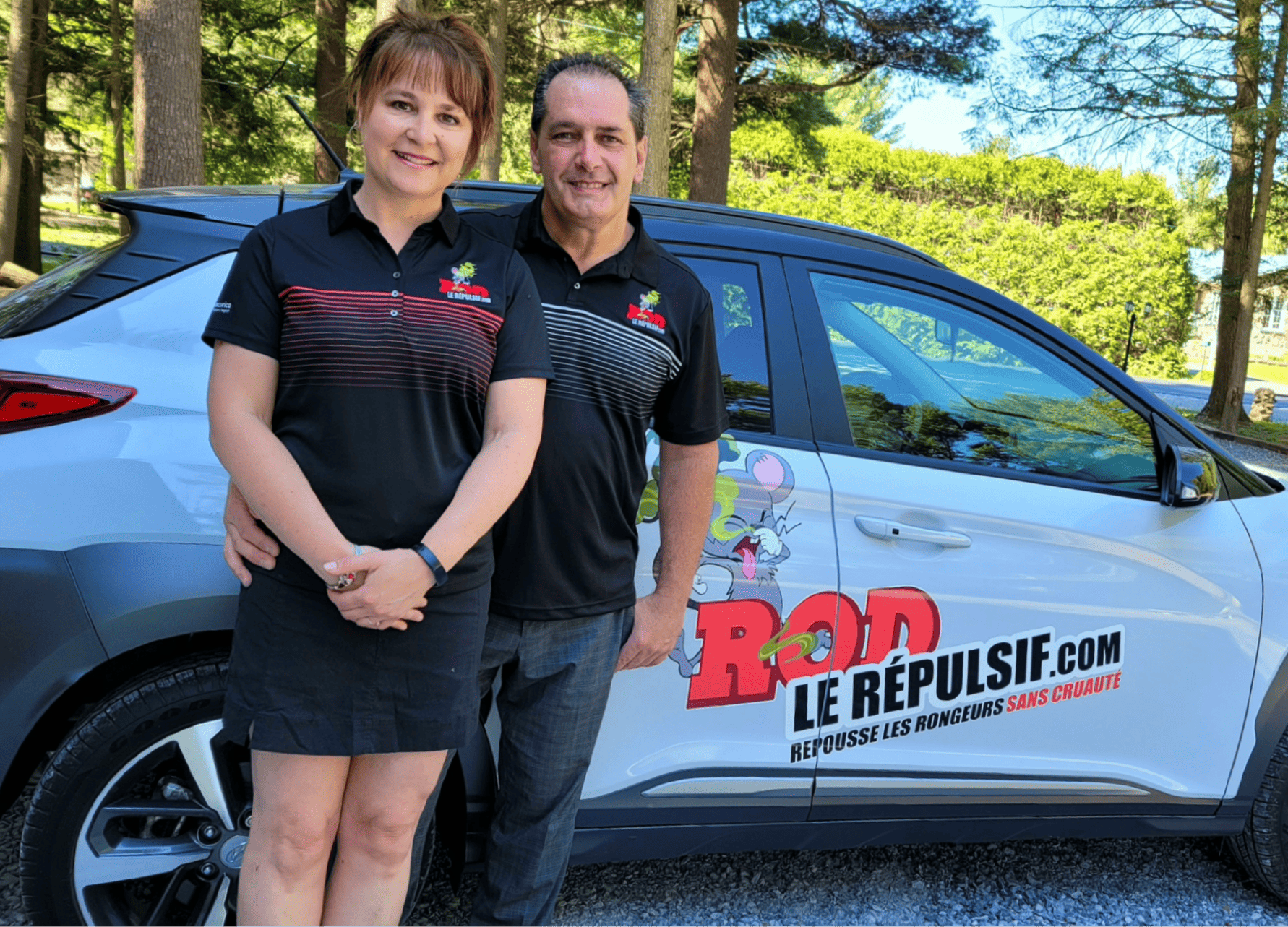 Benoit Legault et sa partenaire se tiennent devant une voiture à hayon dont les portes affichent une publicité de Rod le répulsif