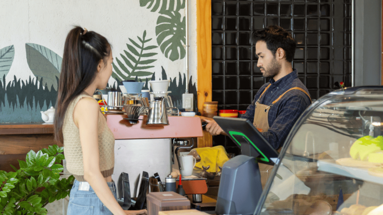 Au comptoir d’un café sympathique, une cliente échange avec le barista.