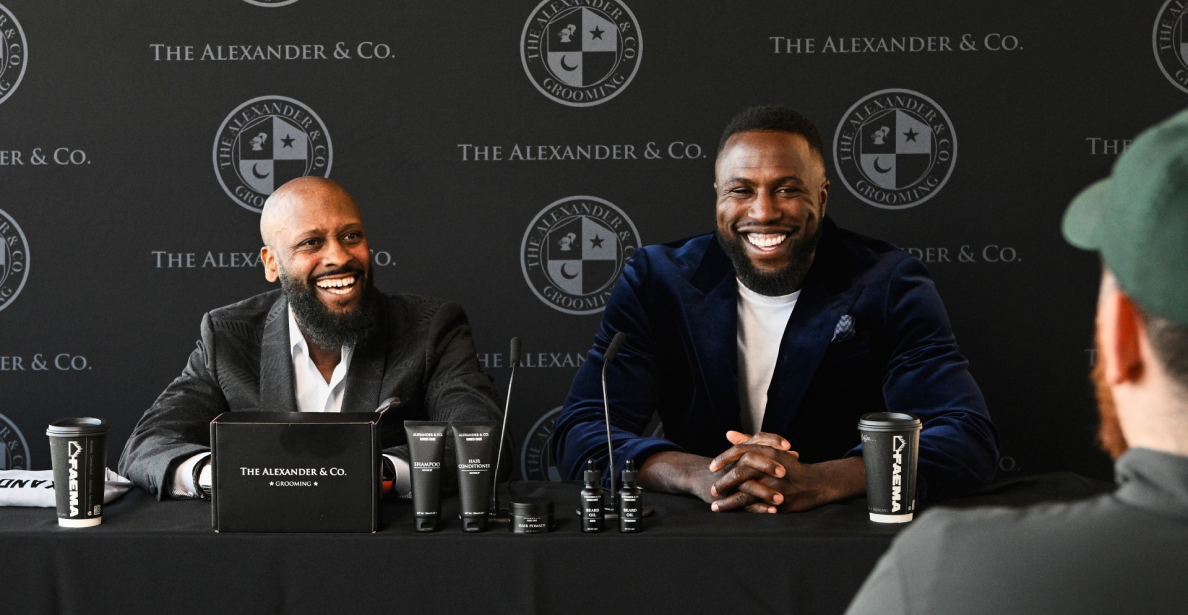 Patrice Alexander et Jozy Altidore lors d’une conférence de presse. Sur la table, des produits de soins Alexander & Co. et des tasses à l’effigie de la marque.