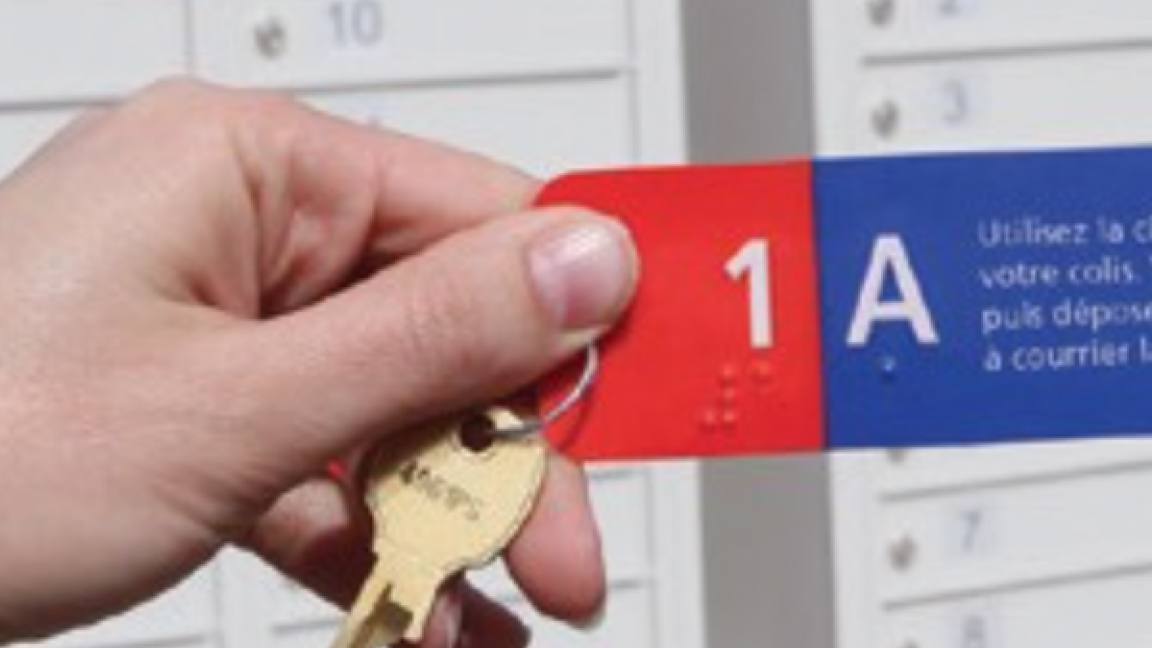 Close up of a community mailbox key and tag showing braille.