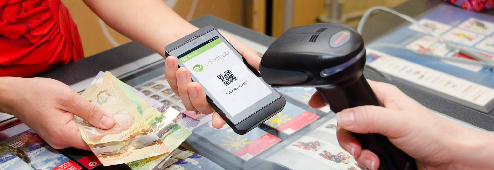 A woman makes a cash payment by presenting her Loadhub QR code at a Canada Post counter.