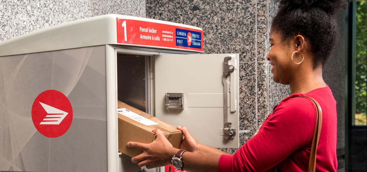 A woman retrieves her package from the Canada Post parcel locker in her apartment building’s mailroom.