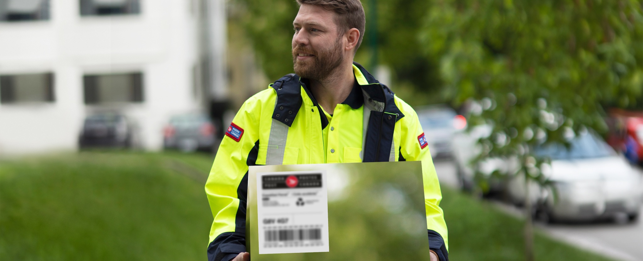 A Canada Post employee carries a carbon- neutral package for delivery.