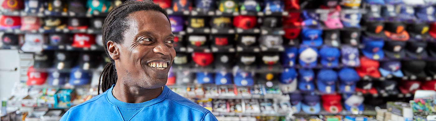 A small business owner is standing in his sporting apparel shop.
