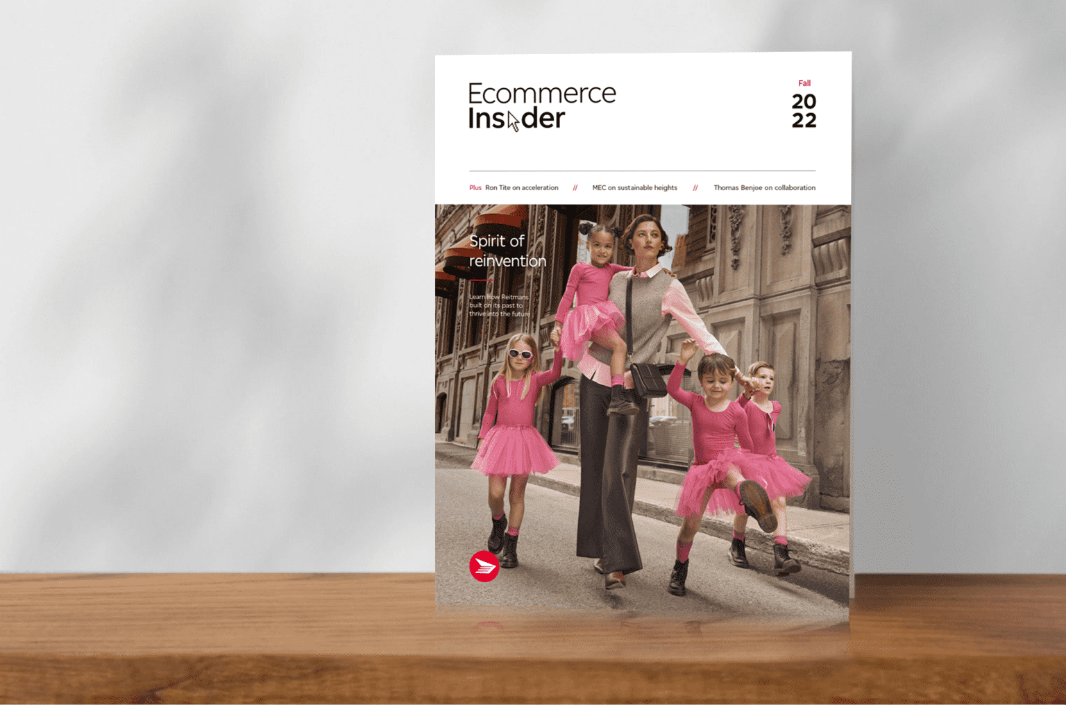 The cover of a past issue of Ecommerce Insider magazine features a chic young woman and three children who wear matching pink outfits and stand on a street together.