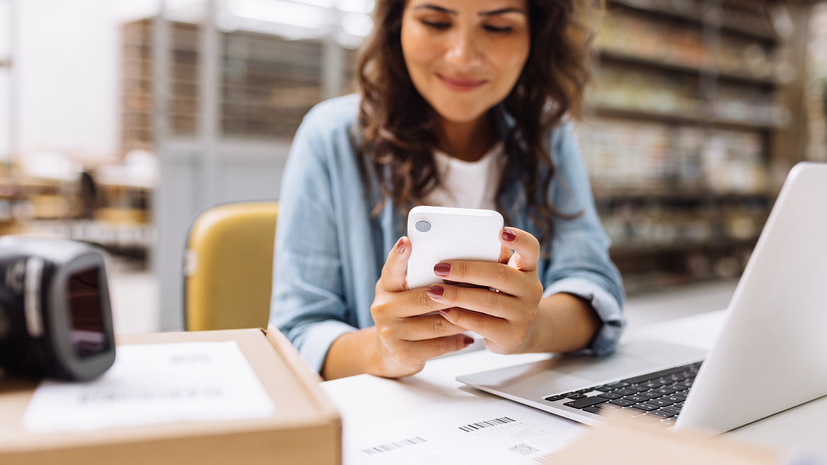 A woman scrolls through a page on her smart phone.
