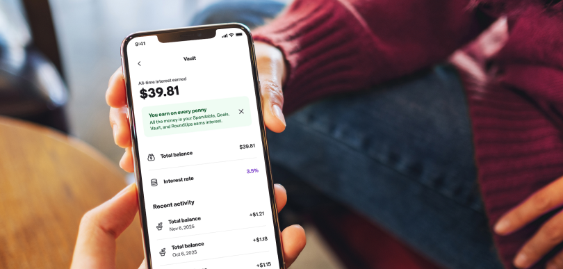 A person holds a smartphone open to the &ldquo;vault&rdquo; page of the Canada Post MyMoney Account delivered with Koho. 