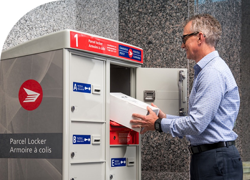 A man collects a parcel from a Canada Post parcel locker in his condo building.