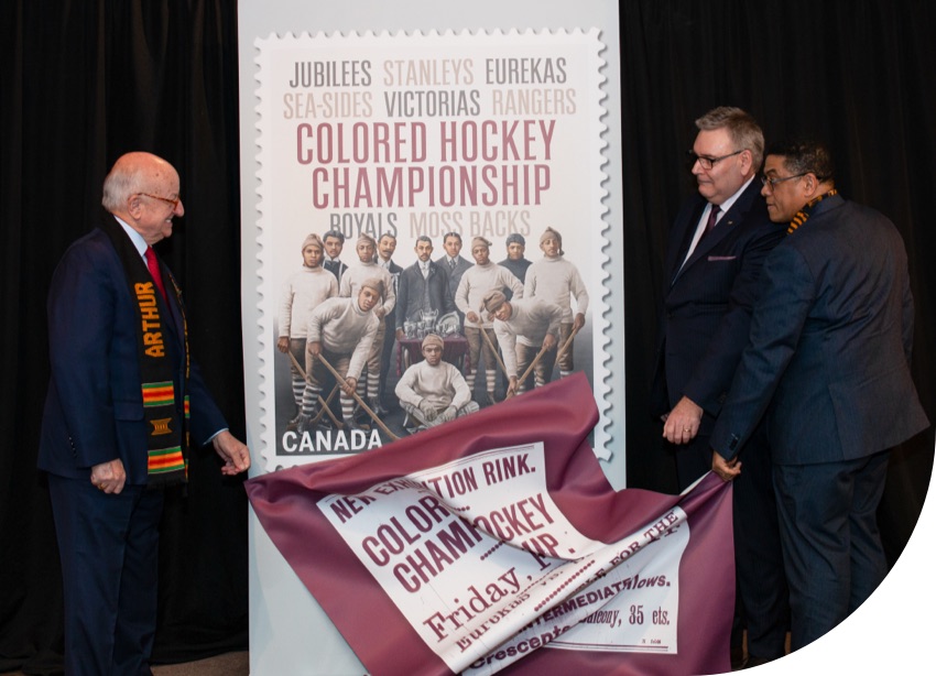 The Honourable Arthur LeBlanc, Doug Ettinger and Craig Smith unveil a stamp celebrating the Colored Hockey Championship.