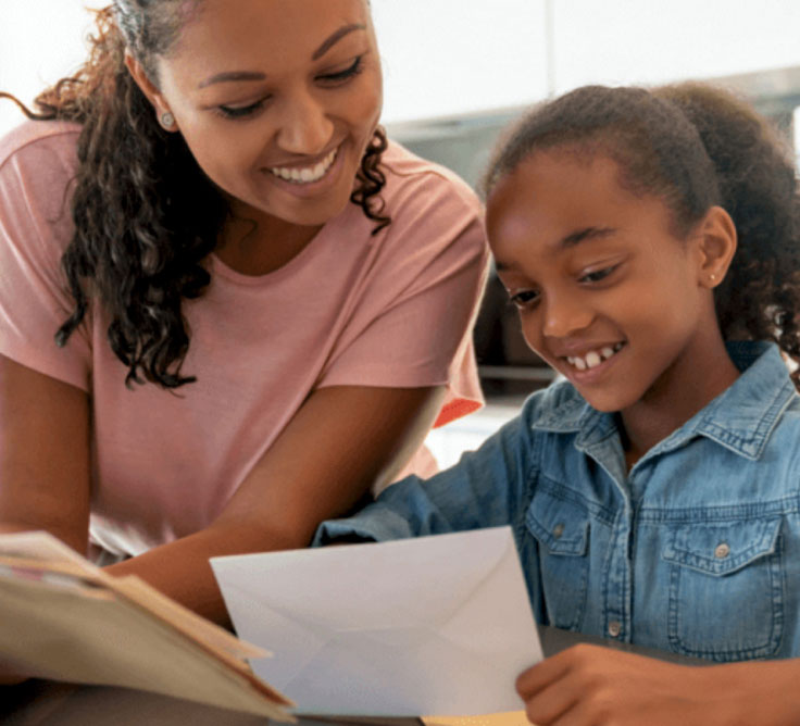 Une mère canadienne et sa fille lisent leur courrier dans leur cuisine