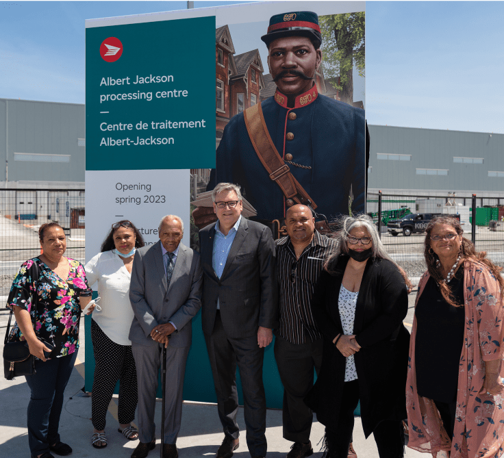 Doug Ettinger, président-directeur général de Postes Canada, et des membres de la famille d’Albert Jackson prennent la pose à la cérémonie de désignation officielle du Centre de traitement Albert-Jackson