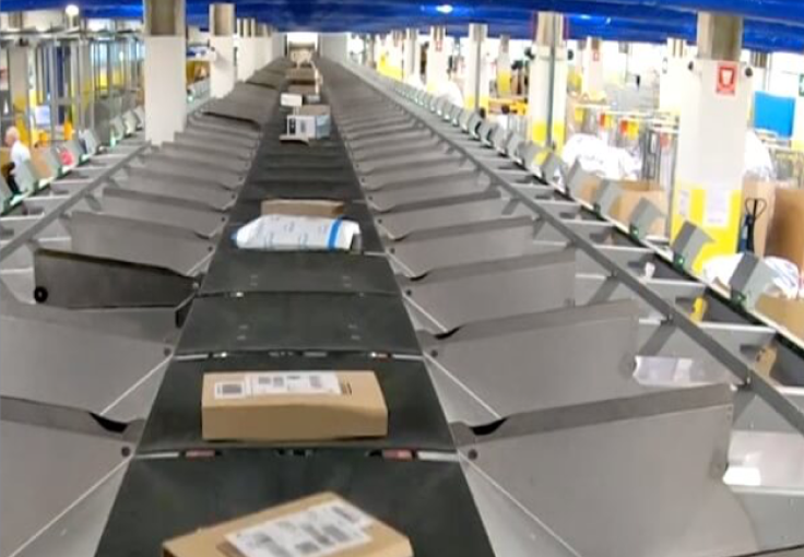 Parcels are automatically sorted on a long conveyor belt at a Canada Post facility.