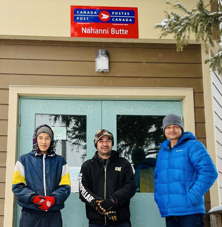 Brodie William Snider, le chef Steve Vital et le gestionnaire de bande Soham Srimani se tiennent devant l’entrée du bureau de poste Nahanni Butte de Postes Canada