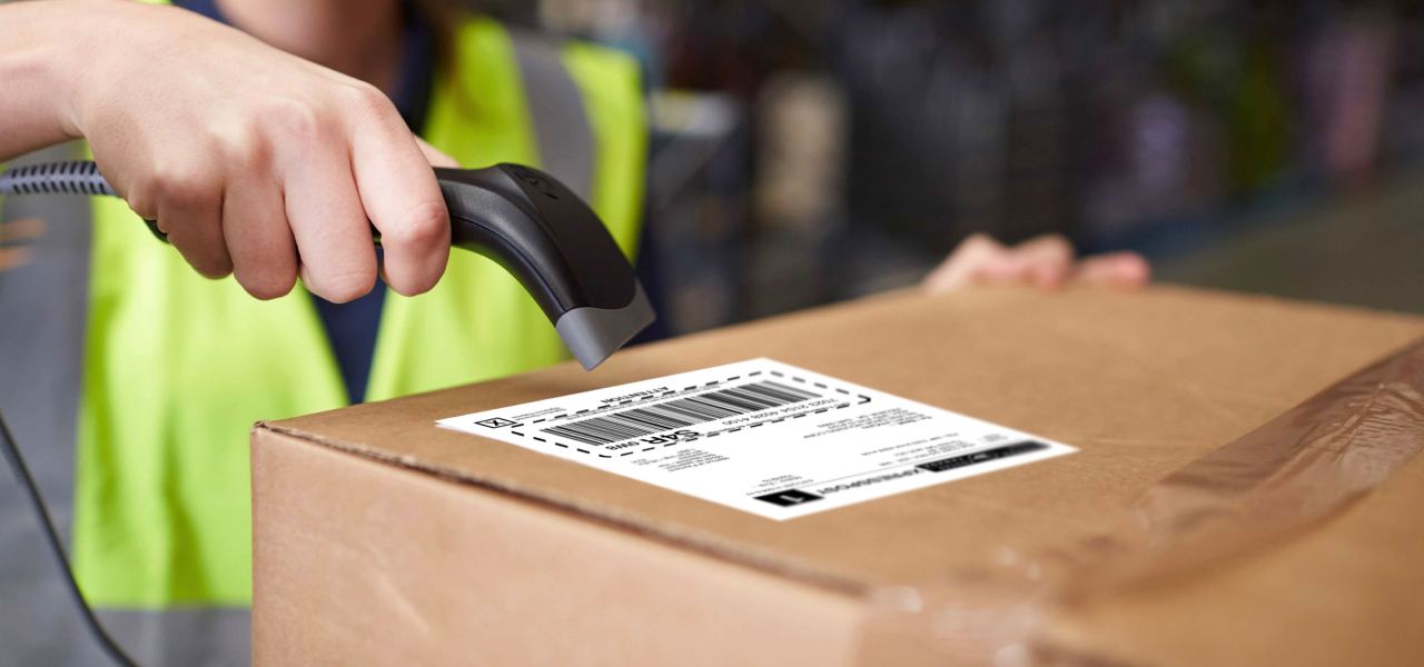 A postal worker scans the Canada Post shipping label on package