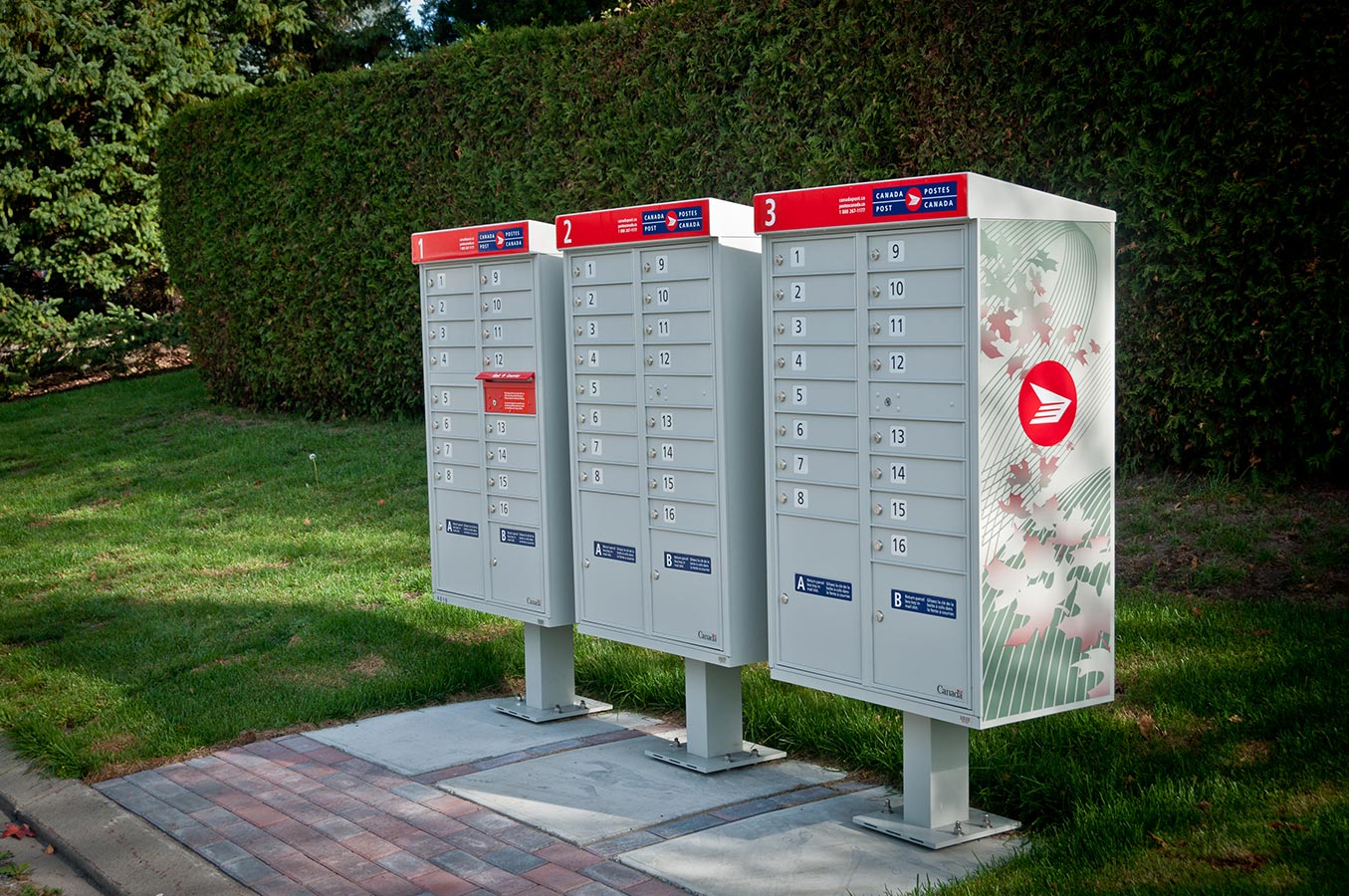 Three community mailboxes side by side in a residential neighbourhood
