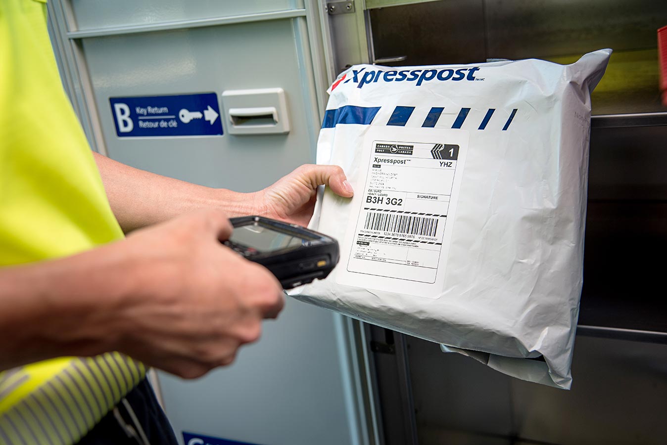 Postal worker scanning an Xpresspost™ package
