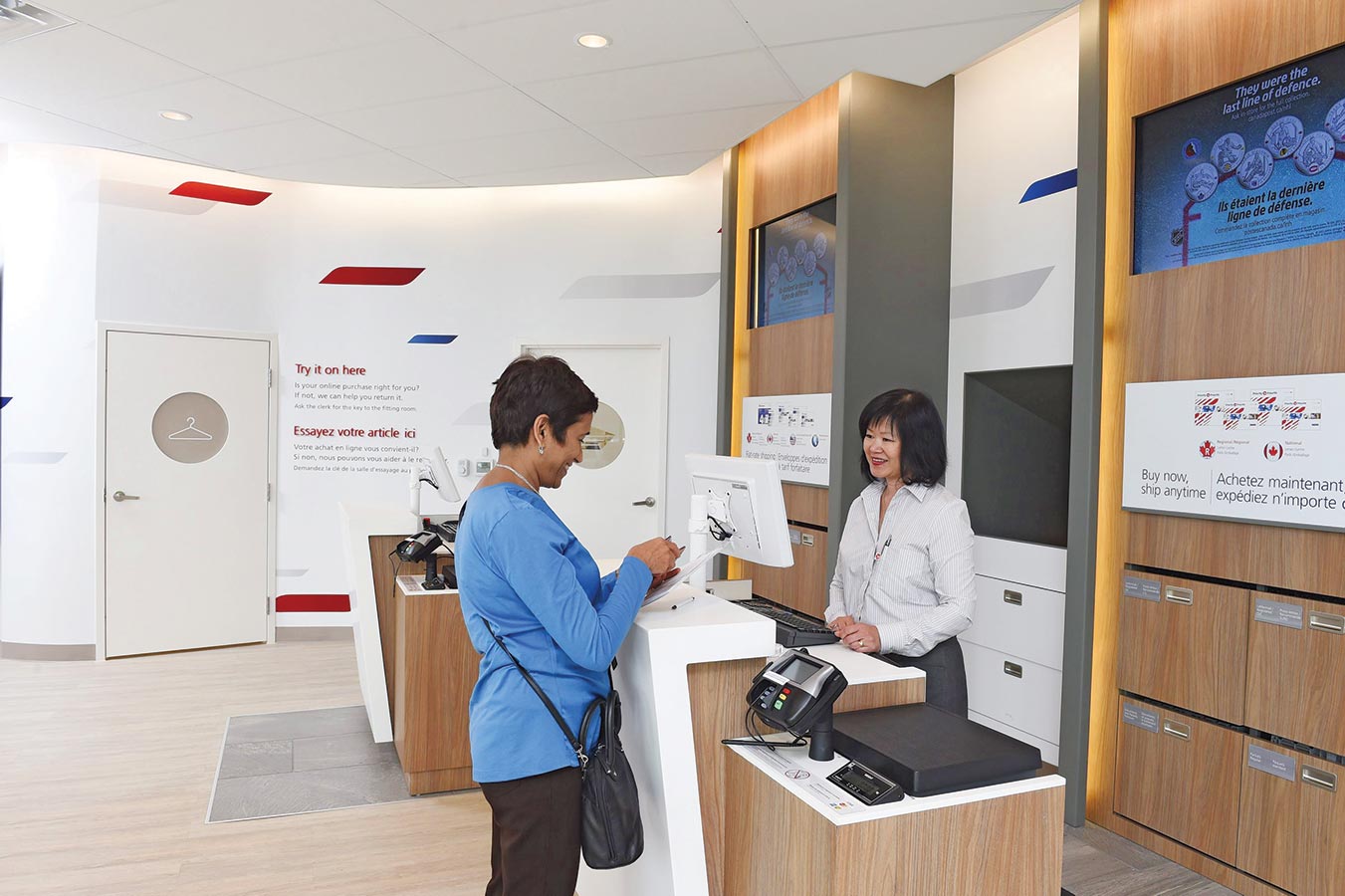 Canada Post retail employee assisting a customer at a post office counter
