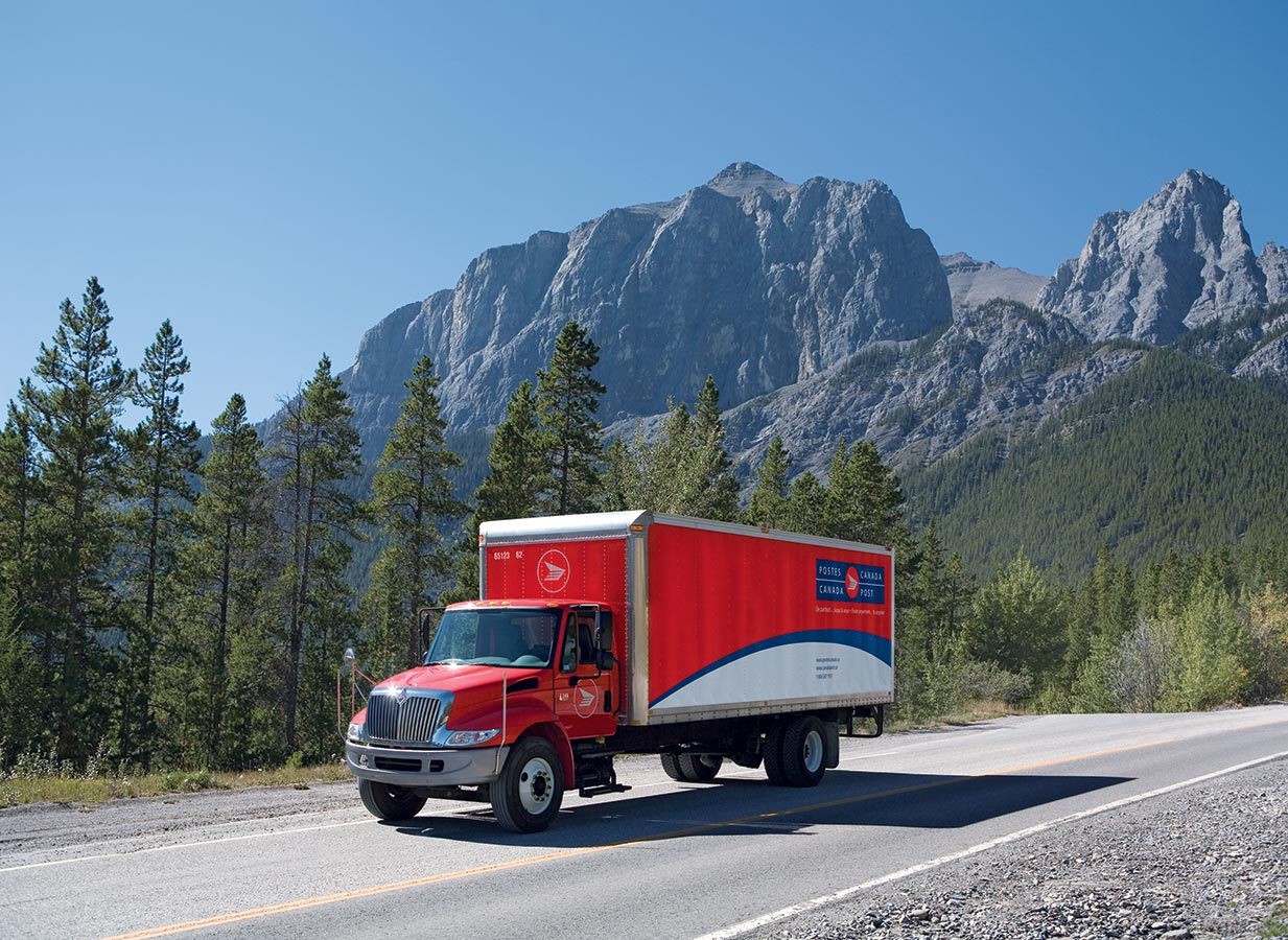 Canada Post delivery truck driving on a mountain road