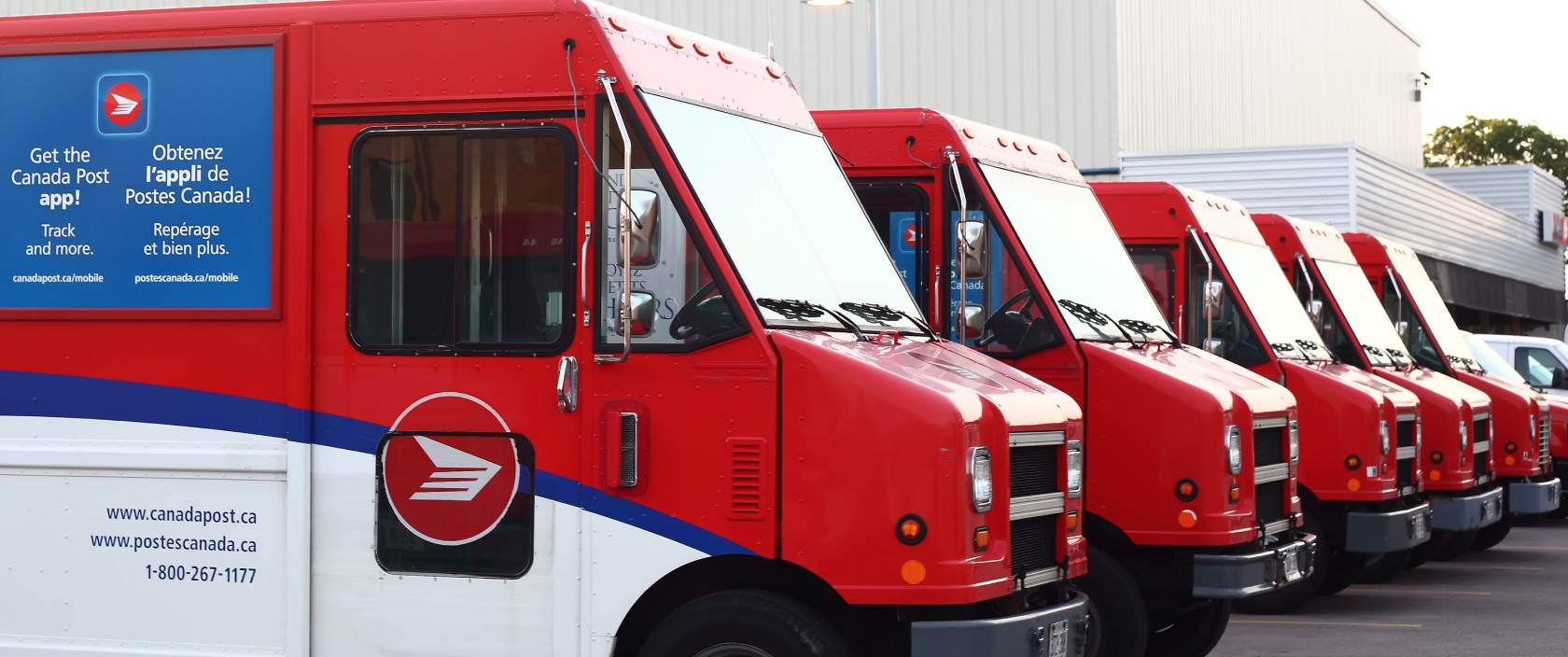 Canada Post delivery trucks parked in a row.