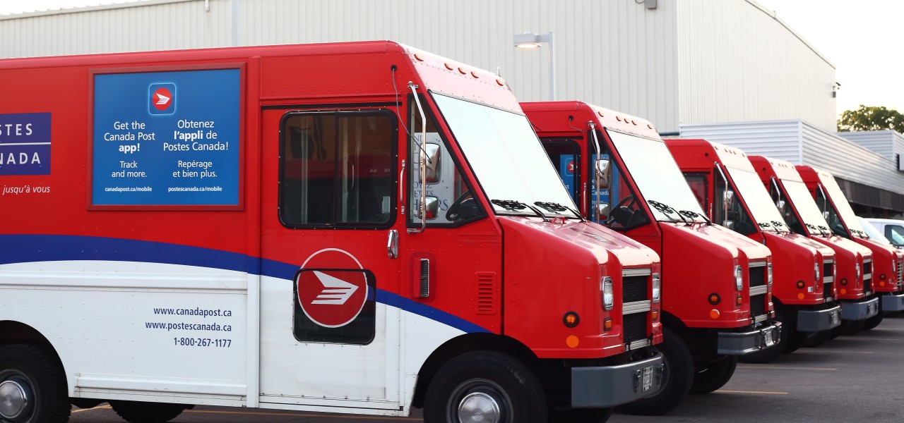 Canada Post delivery trucks parked in a row.