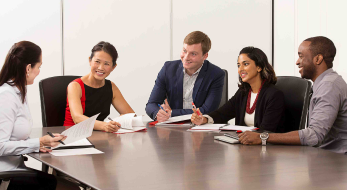 Groupe d’employés assis à une table de réunion.