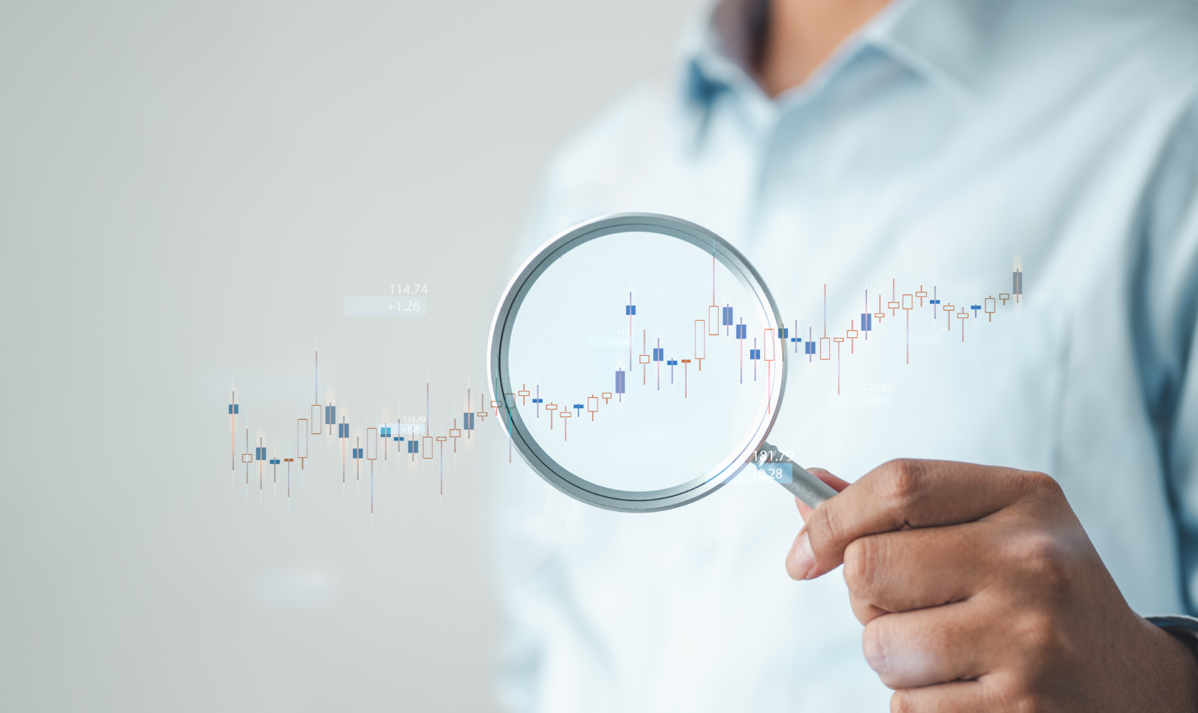 Un homme tient une loupe au-dessus d’un graphique en hausse, soulignant ainsi l’importance de l’analyse des données sur les résultats commerciaux.