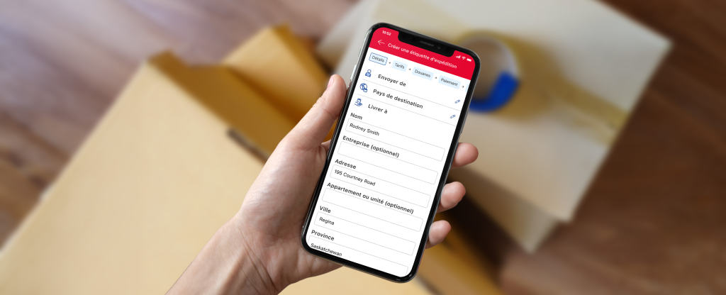 Un téléphone intelligent affiche l’écran de création d’étiquette de l’application de Postes Canada avec les champs de l’expéditeur, du pays de destination et de l’adresse.