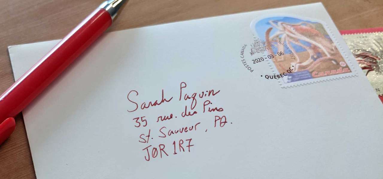 Une enveloppe comportant une adresse de destination, un timbre et un cachet d’oblitération