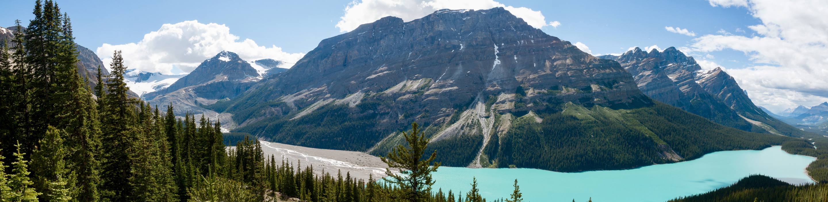 Un lac glaciaire entouré de montagnes vertes.