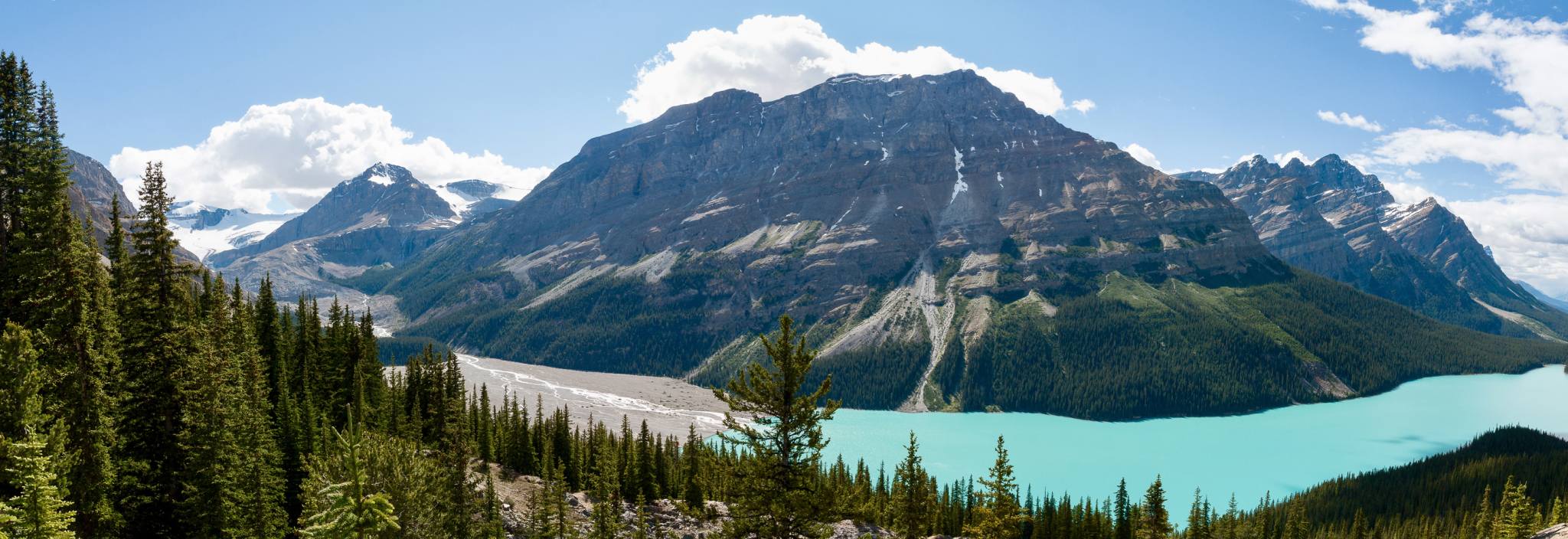 Un lac glaciaire entouré de montagnes vertes.