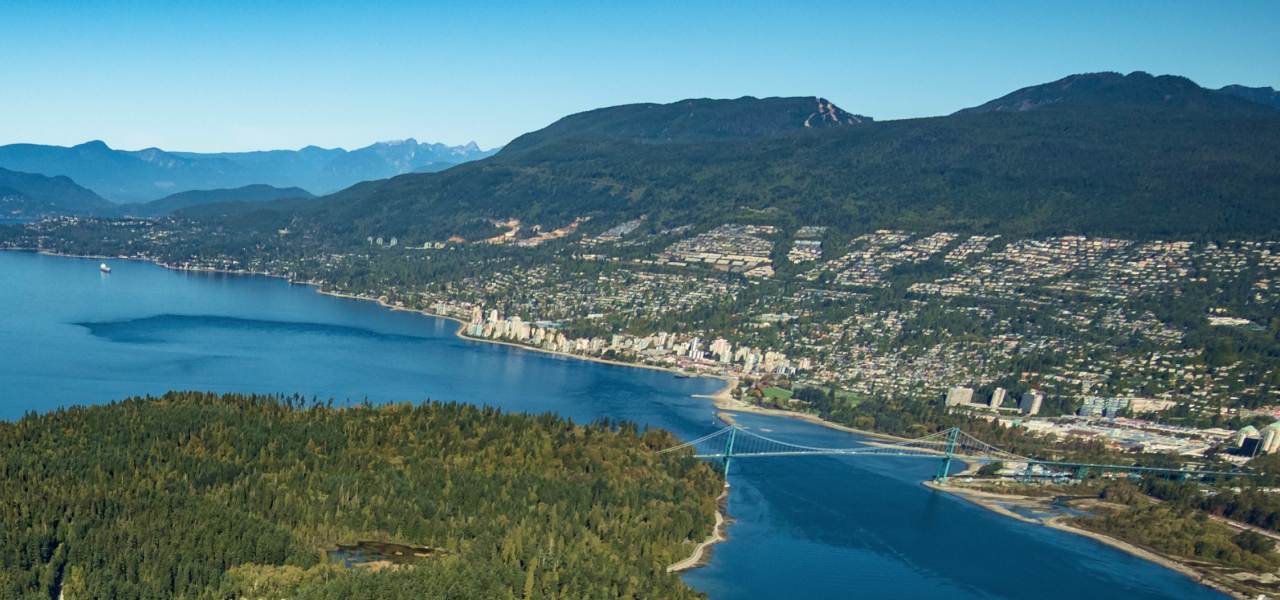 Vue aérienne d’une chaîne de montagnes et d’une communauté côtière.