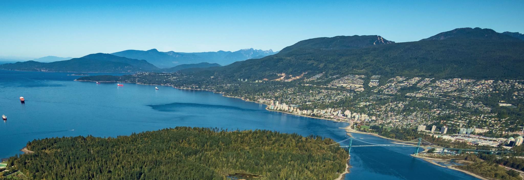 Vue aérienne d’une chaîne de montagnes et d’une communauté côtière.