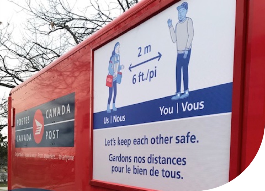 Un véhicule de Postes Canada affiche une illustration sur la distanciation physique.