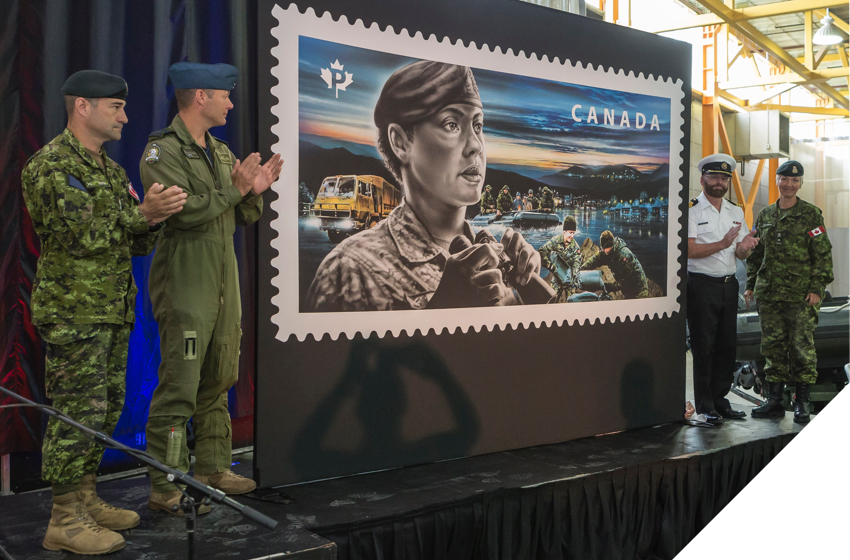 Des membres des Forces armées canadiennes à la BFC Valcartier dévoilant un timbre saluant le personnel des Forces.