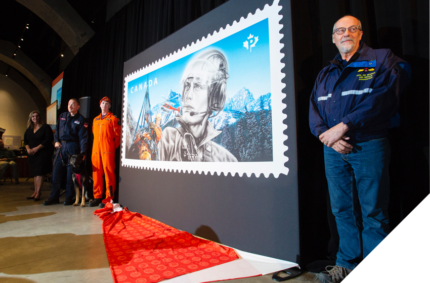 Des experts en recherche et sauvetage dévoilant un timbre consacré aux intervenants d’urgence à Banff, en Alberta.