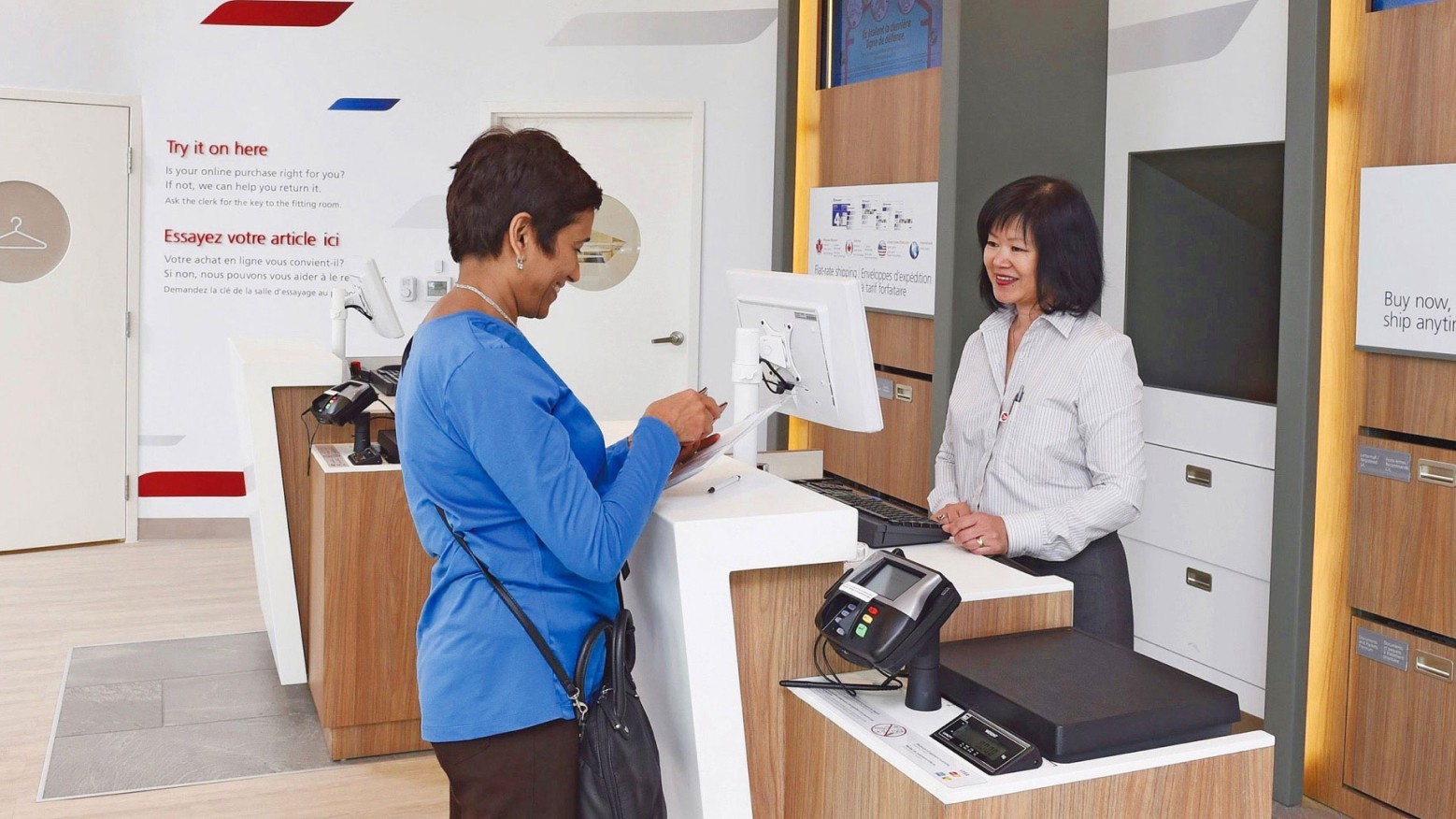 Une femme présente sa pièce d’identité avec photo à un comptoir de Postes Canada pour recharger sa carte Cash Passport.