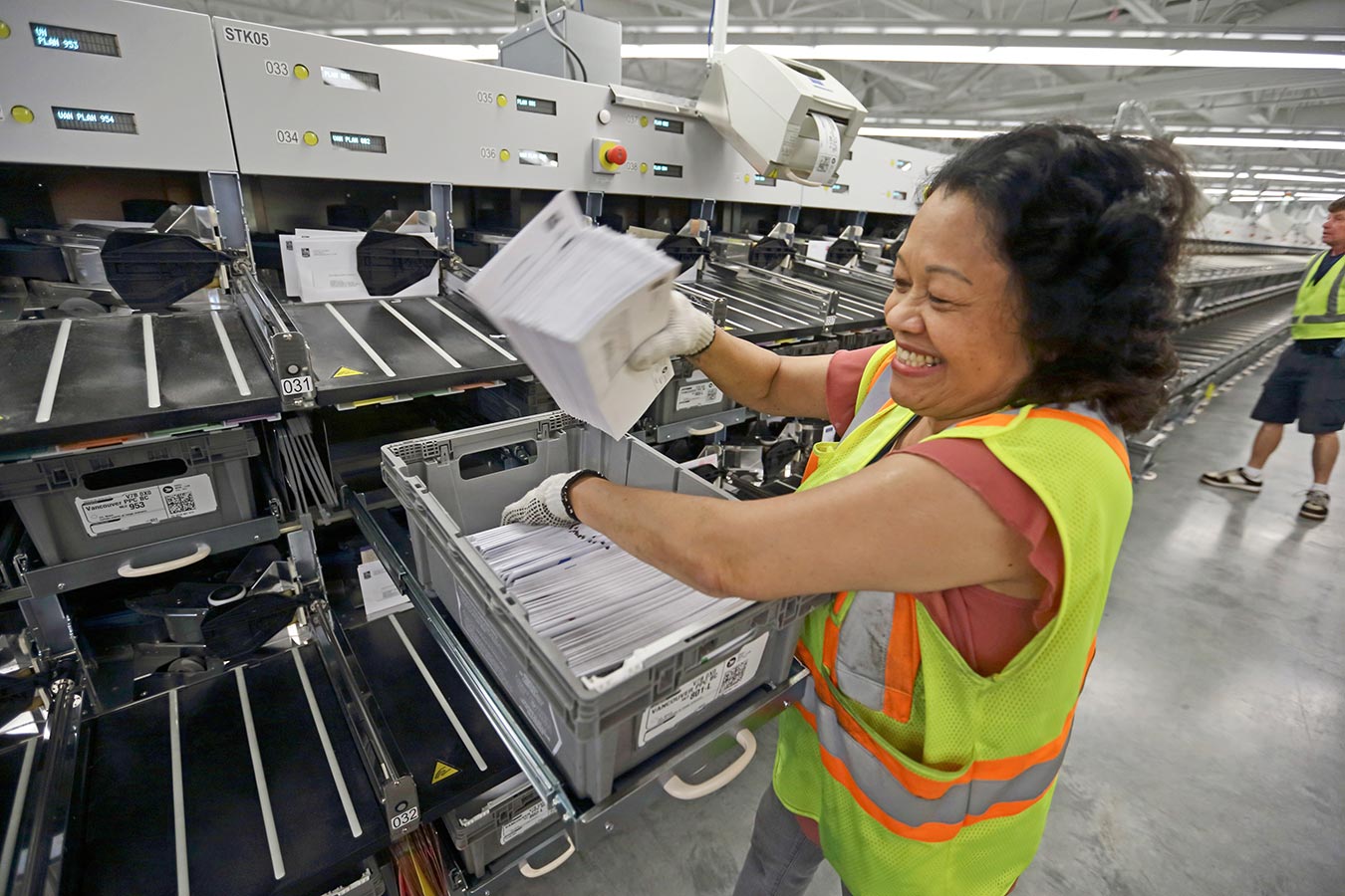 Une employée de Postes Canada trie le courrier dans un centre de traitement