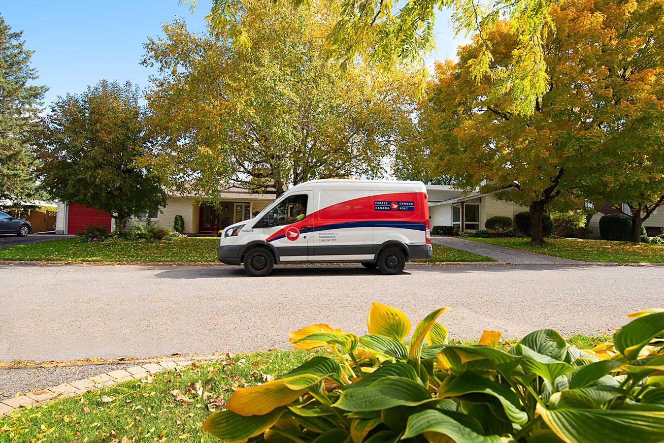 Un camion de livraison de Postes Canada est stationné dans une rue résidentielle