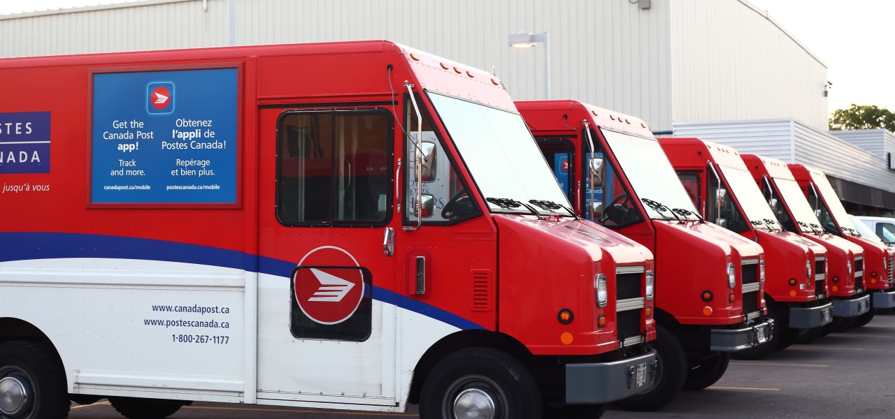 Camions de livraison de Postes Canada stationnés en rangée