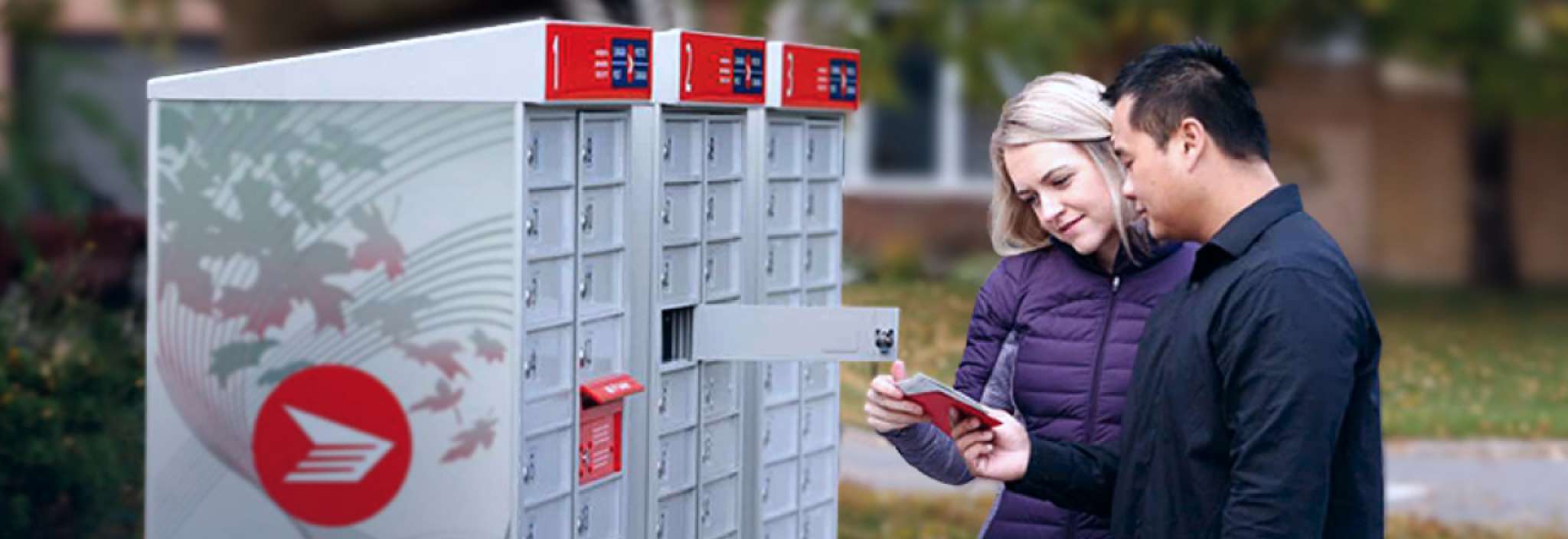 Un couple récupère son courrier dans une boîte postale communautaire de Postes Canada dans un secteur résidentiel
